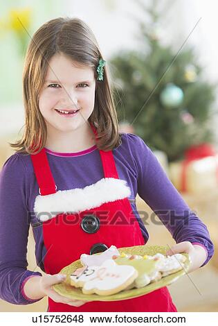 Girl (8-9) holding plate with gingerbread cookies View Large Photo Image Stock Photo - Girl (8-9) holding plate with gingerbread cookies. Fotosearch