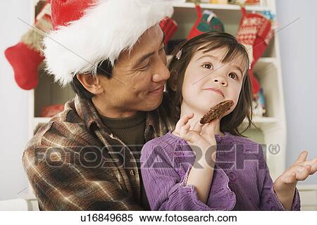 Girl and father wearing santa hat View Large Photo Image Stock Photography - Girl and father wearing santa hat. Fotosearch