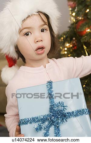 Picture - Girl holding christmas present. Fotosearch
