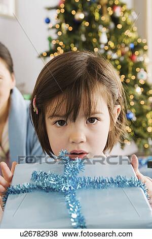 Girl holding christmas present View Large Photo Image Stock Photo - Girl holding christmas present. Fotosearch