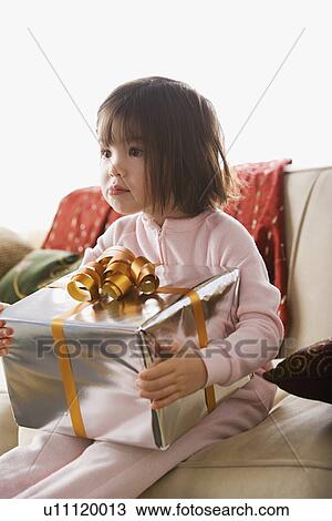 Stock Image - Girl holding present. Fotosearch