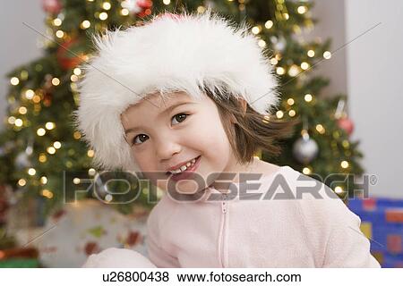 Stock Photo - Girl in front of christmas tree. Fotosearch