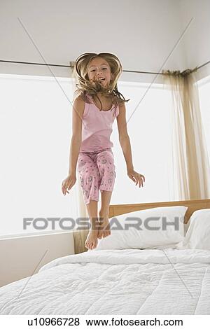Girl jumping on bed View Large Photo Image Stock Photo - Girl jumping on bed. Fotosearch