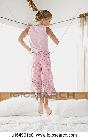 Girl jumping on bed View Large Photo Image Stock Photo - Girl jumping on bed. Fotosearch