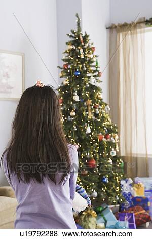 Girl looking at christmas tree View Large Photo Image Stock Photo - Girl looking at christmas tree. Fotosearch