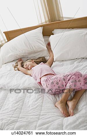 Girl lying in bed in playful pose View Large Photo Image Stock Image - Girl lying in bed in playful pose. Fotosearch