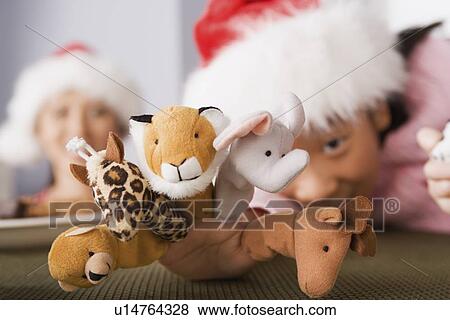 Girl wearing Santa hat playing with finger puppets View Large Photo Image Stock Photo - Girl wearing Santa hat playing with finger puppets. Fotosearch