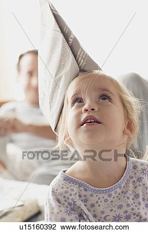 Girl with newspaper hat with father in background View Large Photo Image Stock Image - Girl with newspaper hat with father in background. Fotosearch