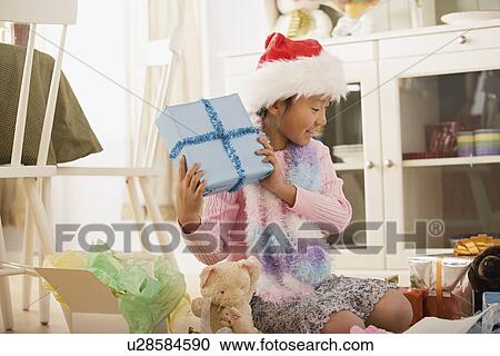 Stock Image - Girl with presents at Christmas morning. Fotosearch