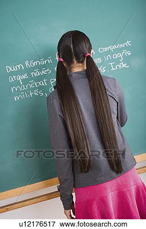 Girl writing Latin text on blackboard View Large Photo Image Stock Photo - Girl writing Latin text on blackboard. Fotosearch
