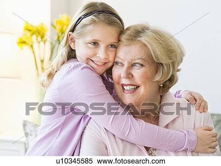 Stock Photography - Granddaughter (8-9) hugging grandmother. Fotosearch