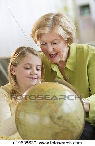 Grandmother with granddaughter (8-9) looking at globe View Large Photo Image Stock Image - Grandmother with granddaughter (8-9) looking at globe. Fotosearch