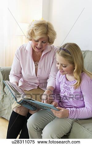 Grandmother with granddaughter (8-9) reading on sofa View Large Photo Image Stock Photography - Grandmother with granddaughter (8-9) reading on sofa. Fotosearch