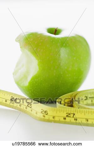 Stock Photograph - Green apple with tape measure. Fotosearch