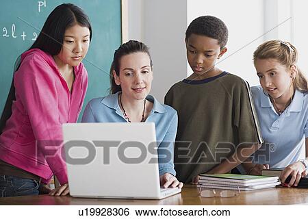 Group of school children with teacher using laptop View Large Photo Image Stock Photograph - Group of school children with teacher using laptop . Fotosearch