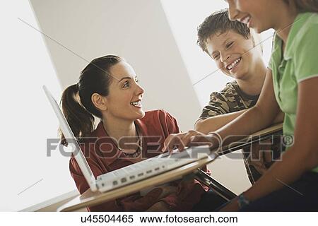 Group of school children with teacher using laptop View Large Photo Image Stock Photography - Group of school children with teacher using laptop . Fotosearch