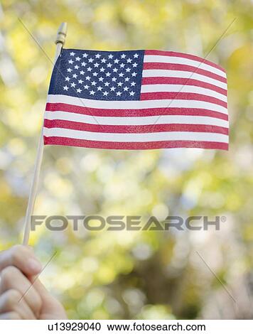 Stock Image - hand holding American flag. Fotosearch