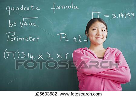 Happy Asian girl standing against blackboard after solving mathematical equation View Large Photo Image Stock Image - Happy Asian girl standing against blackboard after solving mathematical equation. Fotosearch