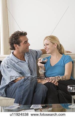 Stock Photo - Happy couple sitting on sofa. Fotosearch