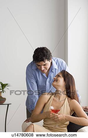 Stock Photo - Happy couple together, woman holding cocktail. Fotosearch