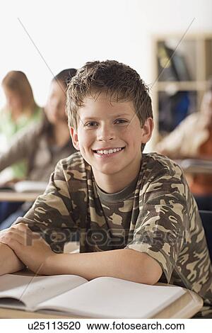 Happy schoolboy sitting in classroom View Large Photo Image Stock Image - Happy schoolboy sitting in classroom. Fotosearch