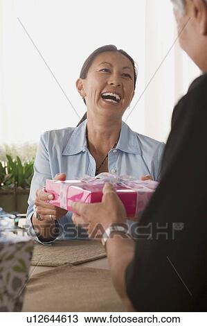 Laughing woman receiving present View Large Photo Image Stock Image - Laughing woman receiving present. Fotosearch