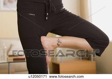 Stock Image - Legs of woman in yoga pose. Fotosearch