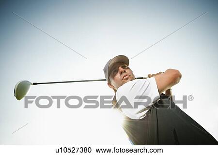 Low angle view of man playing golf View Large Photo Image Stock Image - Low angle view of man playing golf. Fotosearch