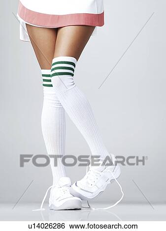 Low section of woman wearing sneakers and knee-high socks View Large Photo Image Stock Photograph - Low section of woman wearing sneakers and knee-high socks. Fotosearch