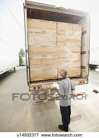 Stock Photo - Man checking load on truck trailer. Fotosearch