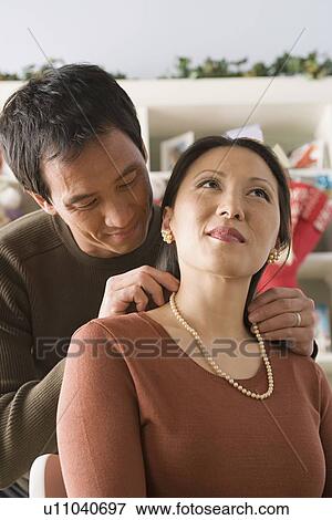 Man fastening necklace on woman's neck View Large Photo Image Stock Photo - Man fastening necklace on woman's neck. Fotosearch