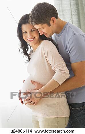 Man hugging pregnant woman View Large Photo Image Picture - Man hugging pregnant woman. Fotosearch