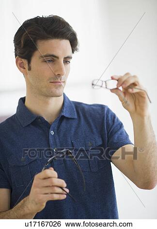 Man looking at spectacles in store View Large Photo Image Stock Photograph - Man looking at spectacles in store. Fotosearch