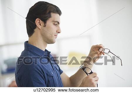 Man looking at spectacles in store View Large Photo Image Stock Photography - Man looking at spectacles in store. Fotosearch