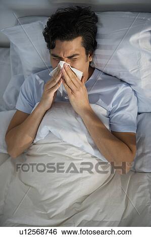 Man lying in bed and blowing nose View Large Photo Image Stock Photograph - Man lying in bed and blowing nose. Fotosearch