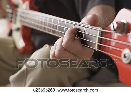 Stock Photo - Man playing bass guitar. Fotosearch