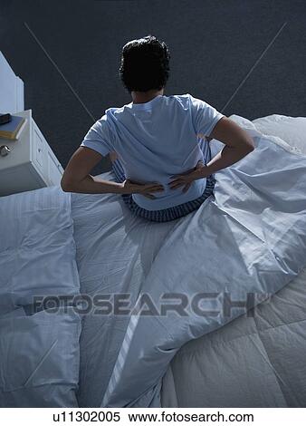 Stock Photography - Man sitting on bed . Fotosearch