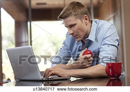 Man using laptop at home View Large Photo Image Stock Photo - Man using laptop at home. Fotosearch