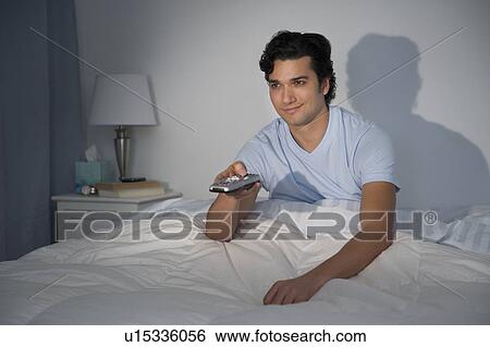 Man watching tv in bed View Large Photo Image Stock Photograph - Man watching tv in bed. Fotosearch