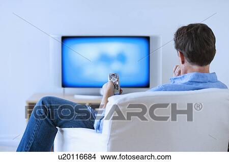 Picture - Man watching tv in living room. Fotosearch