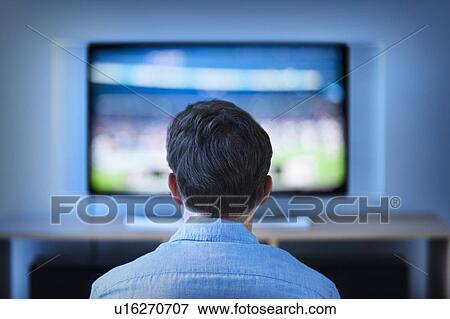 Man watching tv in living room View Large Photo Image Stock Photo - Man watching tv in living room. Fotosearch