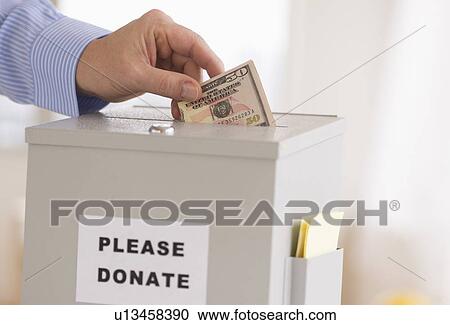 Man's hand putting dollars into donation box View Large Photo Image Stock Image - Man's hand putting dollars into donation box. Fotosearch