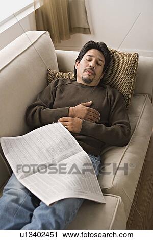 Mature man sleeping on sofa with newspaper View Large Photo Image Stock Image - Mature man sleeping on sofa with newspaper. Fotosearch