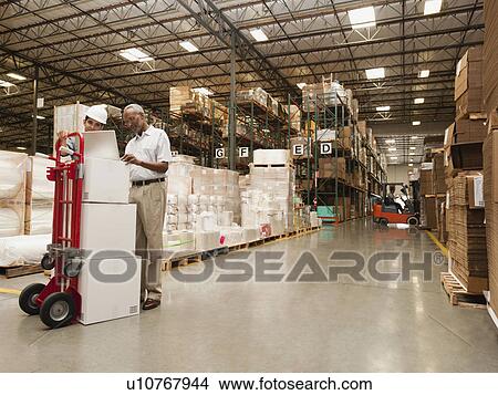 Picture - Men working in warehouse. Fotosearch