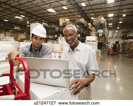 Stock Photo - Men working in warehouse. Fotosearch