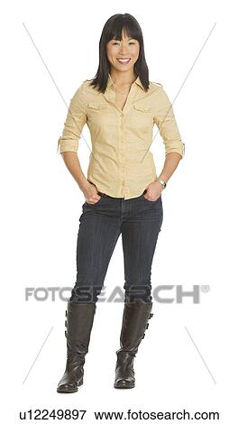 Stock Photo - Mid adult smiling woman standing, studio shot. Fotosearch