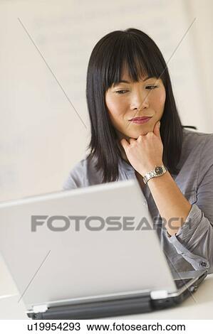 Mid adult woman using laptop View Large Photo Image Stock Image - Mid adult woman using laptop. Fotosearch