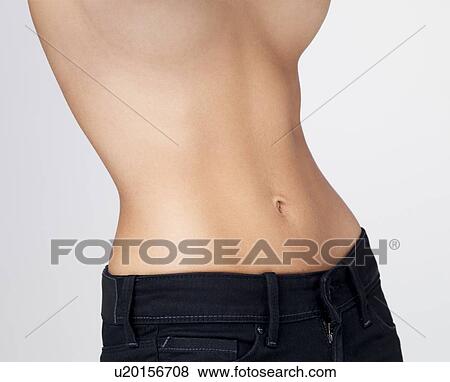 Stock Photo - Midsection of slim young woman with flat belly. Fotosearch
