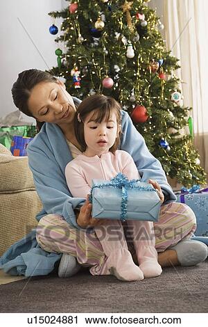 Stock Image - Mother and daughter at Christmas morning. Fotosearch