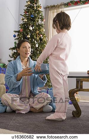 Stock Image - Mother and daughter at Christmas morning. Fotosearch